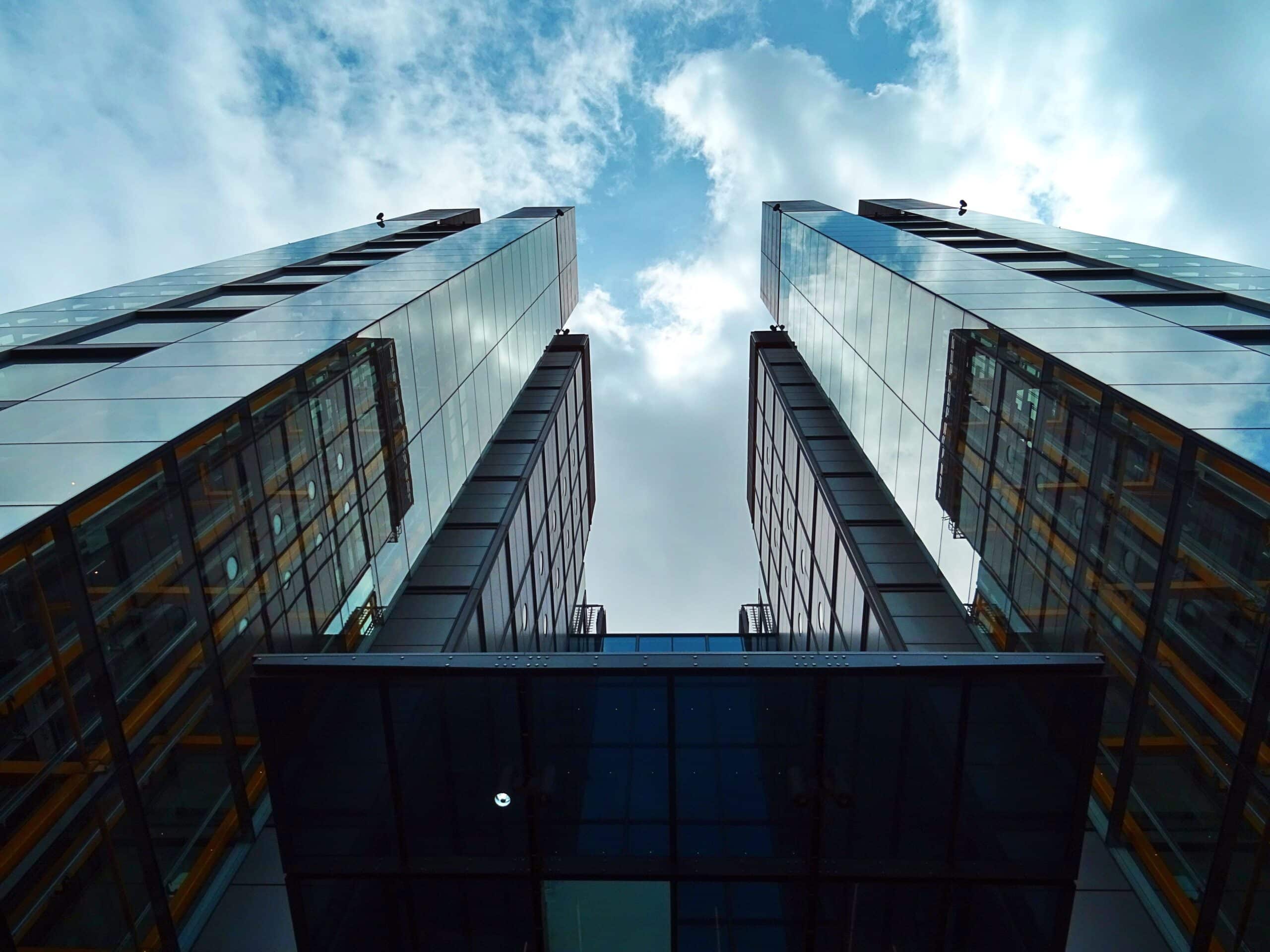 looking up to two full glass on the outside skyscrapers