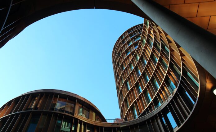 shot from the ground looking up to some round / curved modern buildings with big windows