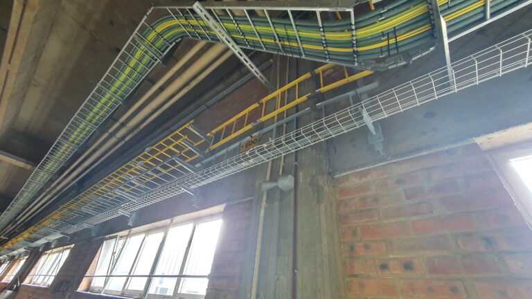 Picture of the warehouse wall showing cables and some windows